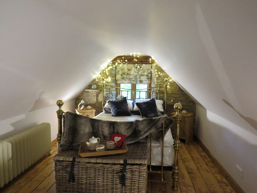 Brass bed with fairy lights and exposed stone