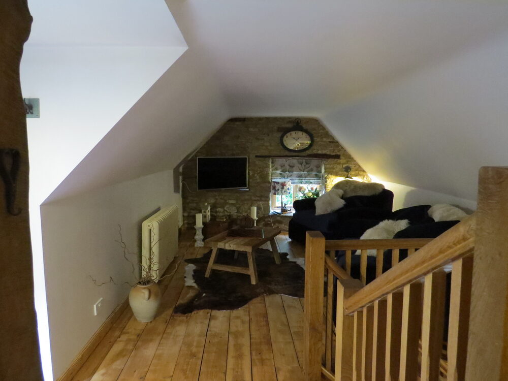 Sitting room with exposed stone and clock